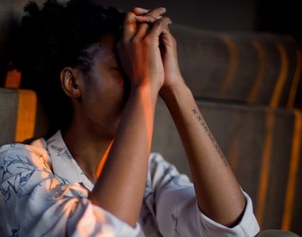 Woman sitting with her hands to her head