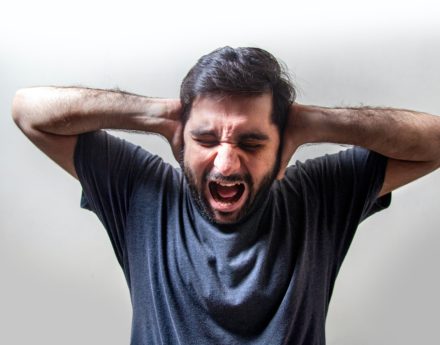 men covering his ears