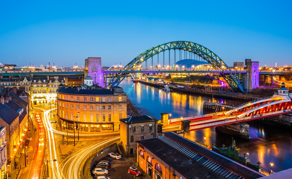 Night time wide shot of Newcastle upon Tyne's quayside, with a view of the swing bridge, Tyne bridge, and millennium bridge