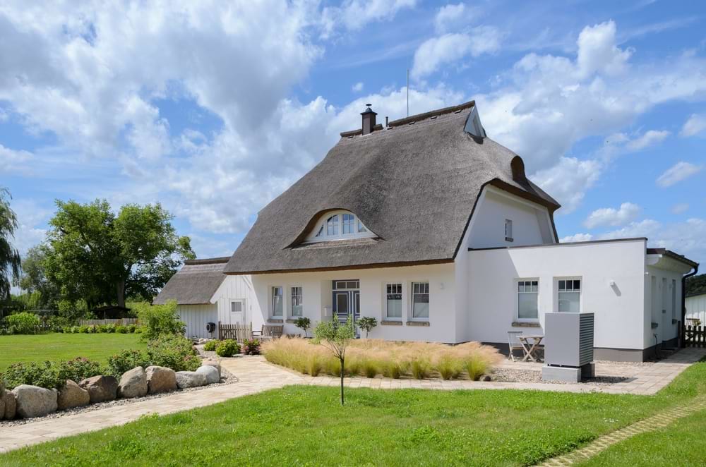 modern, white thatched cottage with grounds
