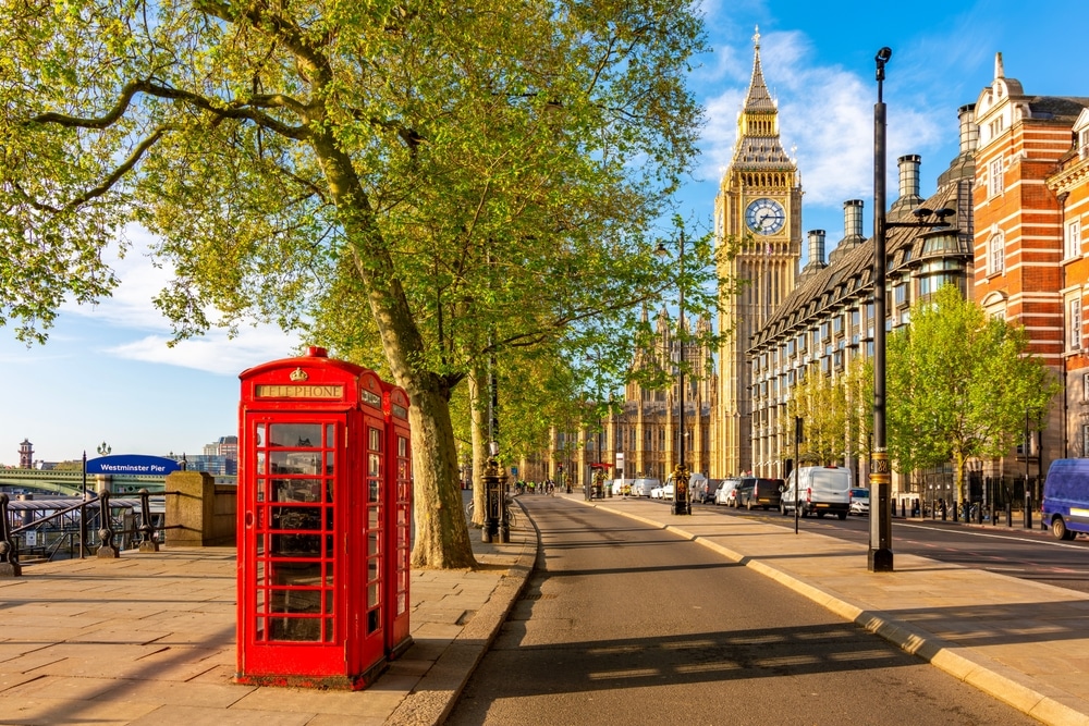 two red phone boxes in foreground and big ben in background in Westminster, London