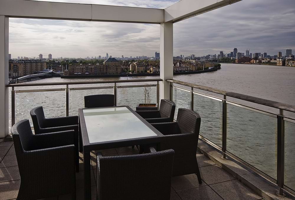 penthouse terrace in London with table and chairs and view of River Thames